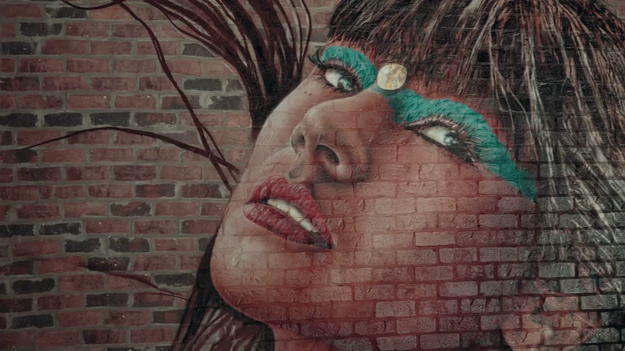 Colorful mural artwork layered over textured brick