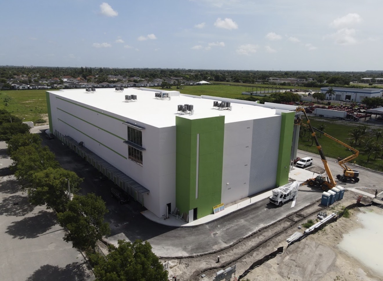 Elevated daytime view of a white and green storage building